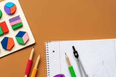 Set of supplies for mathematics and for school. Fractions, rulers, pencils, notepad on brown background,  Back to school, fun education concept