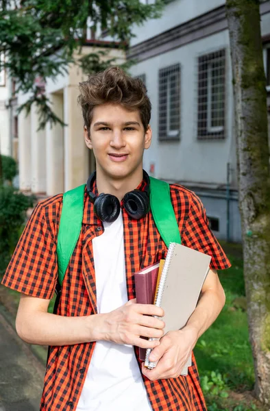Cute Teenager Red Shirt Headphones Backpack Holding Notebook Front His — Foto Stock