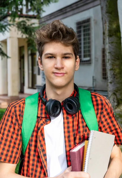 Cute Teenager Red Shirt Headphones Backpack Holding Notebook Front His — Stockfoto
