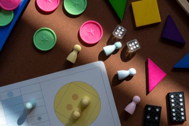 Different desktop games, figures, dices, parts on the brown table. Home entertaiment, indoor games