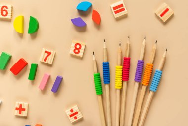 School supplies, math fractions, pencils, numbers, notepad on beige background. Back to school, education concept background