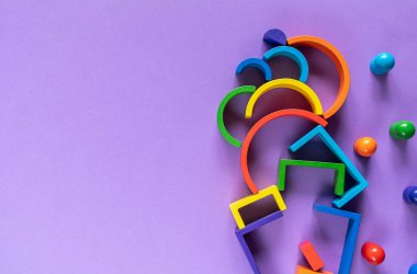 Çok renkli soyut gökkuşağı arkaplanı. Ahşap çocuk oyuncakları menekşe kağıdında. Eğitici oyuncak blokları, gökkuşağı. Anaokulu, anaokulu veya kreş oyuncakları.