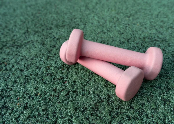 Różowe Hantle Zielonym Tle Urządzenia Fitness Sprzęt Sportowy Zbliżenie — Zdjęcie stockowe