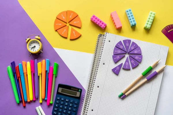 School supplies on purple, yellow, white background. Back to school, education concept background.