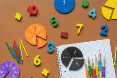 Set of supplies for mathematics and for school. Fractions, rulers, pencils, notepad on brown background, Back to school, fun education concept