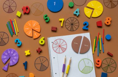 Set of supplies for mathematics and for school. Fractions, rulers, pencils, notepad on brown background, Back to school, fun education concept