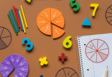 Set of supplies for mathematics and for school. Fractions, rulers, pencils, notepad on brown background, Back to school, fun education concept