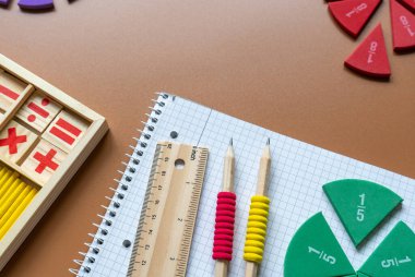Set of supplies for mathematics and for school. Fractions, rulers, pencils, notepad on brown background, Back to school, fun education concept
