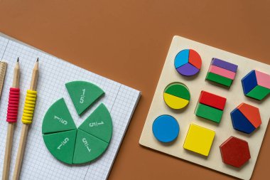 Set of supplies for mathematics and for school. Fractions, rulers, pencils, notepad on brown background, Back to school, fun education concept