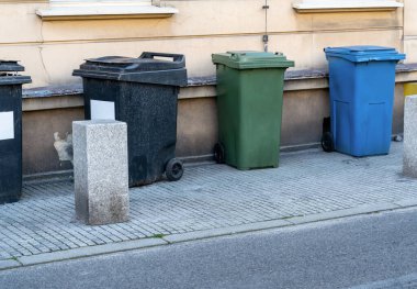 Siyah, mavi, sarı, yeşil çöp konteynırları. Atıkları ayır, çevre kavramını koru. Atıkları ayır, çöp kutularını ayır. Kağıt, plastik, cam ve organik renkli çöp tenekeleri.
