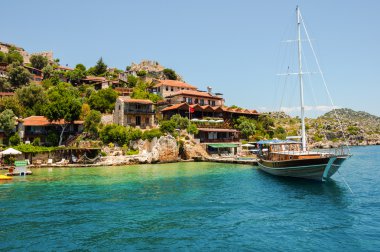 arka plandaki sahil kekova, yelkenli