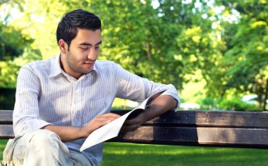 genç yakışıklı bir adamla parkta kitap okumak