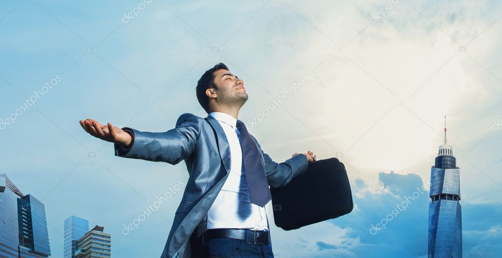 Successful businessman with arms outstretched celebrating success