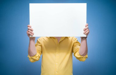 Mavi arka planda beyaz panoyla yüzünü örten genç kadınlar, sarı gömlekli. Boş ilan panosu ve mesaj için boş yeri olan boş bir reklam panosu gösteren bir adam. Stüdyo çekimi