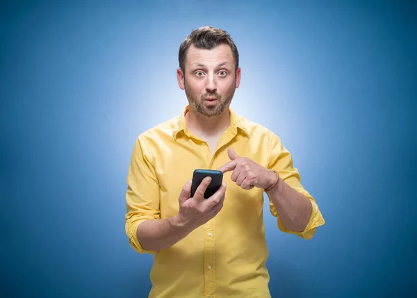 Surprised Young Man Shows Mobile Phone Blank Display Space Your — Stock Photo, Image