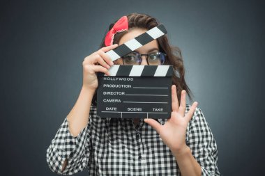 Koyu gri arka planda film şeridi tutan genç bir kadın. Siyah arka plan. Stüdyo çekimi