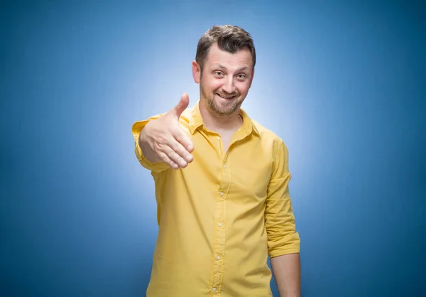 Glimlachende Jongeman Die Hand Reikt Voor Een Handdruk Een Blauwe — Stockfoto