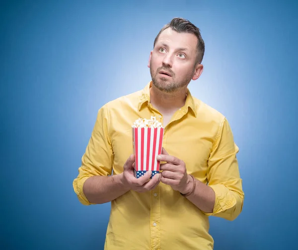 Geschockter Typ Mit Popcorn Vor Blauem Hintergrund Kleider Gelben Hemd — Stockfoto
