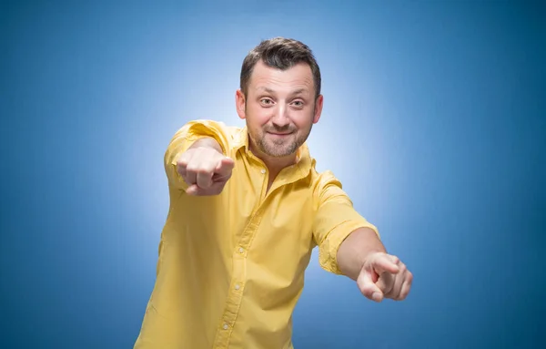 Verspielt Lächelnder Junger Mann Der Einen Auf Blauem Grund Anfasst — Stockfoto