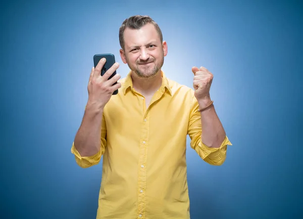 Homem Nervoso Mostrando Seu Telefone Celular Sobre Fundo Azul Vestidos — Fotografia de Stock