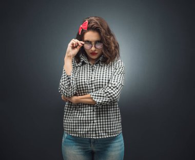 Şüpheli kavramı. Koyu gri arka planda sana bakan güvensiz genç kadın. Siyah arka plan. Stüdyo çekimi