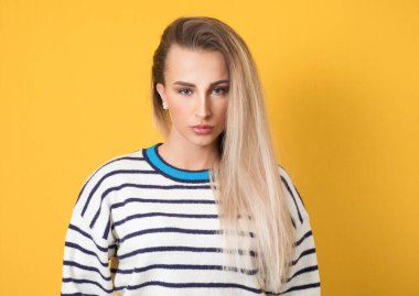 Sarı arka planda izole edilmiş güzel bir genç kadının kafa ve omuzlarından fotoğrafı. Ön manzara. Güzel kızın yüzünü kapat. Stüdyo çekimi