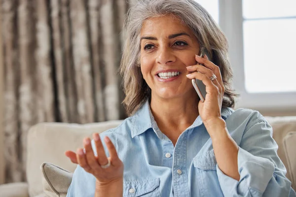 Uśmiechnięta Dojrzała Kobieta Wykonująca Połączenie Przez Telefon Komórkowy Domu — Zdjęcie stockowe