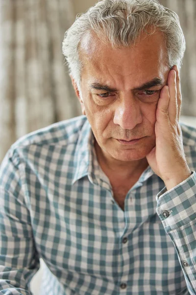 Head And Shoulders Shot Of Worried Senior Man At Home