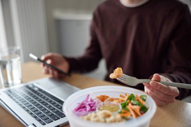 Office Deak 'te Laptop kullanırken Sağlıklı Yemek Yiyen Adam Kapanışı