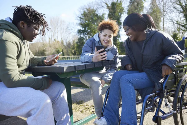 Teenagermädchen Rollstuhl Mit Freunden Schaut Sich Soziale Medien Auf Mobiltelefonen — Stockfoto