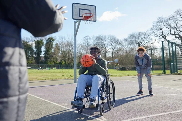 Arkadaşlarıyla Tekerlekli Sandalyedeki Genç Çocuk Parkta Basketbol Oynuyor — Stok fotoğraf