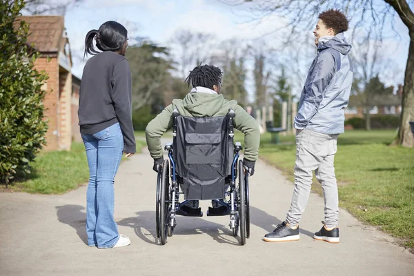 Tekerlekli Sandalyedeki Genç Çocuk Parkta Arkadaşlarıyla Takılıyor Konuşuyor Gülüyor — Stok fotoğraf