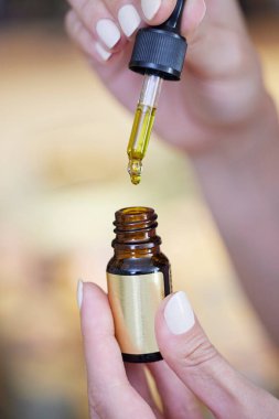 Close Up Of Hand Holding Dropper With CBD Medicinal Cannabis Oil