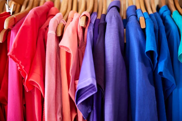 Colourful Sustainable Clothing Hanging On Rail In Charity Or Thrift Store Selling Sustainable Fashion