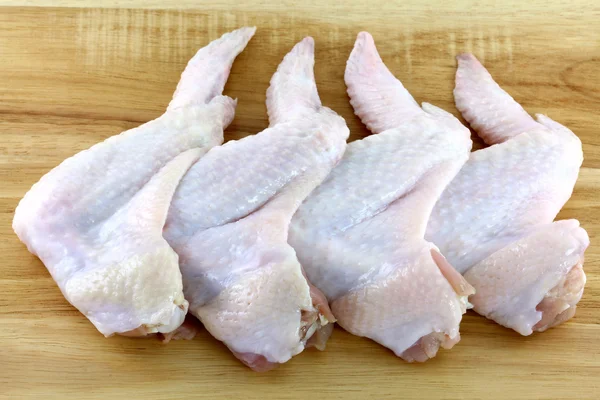 Alitas de pollo en una tabla de cortar de madera —  Fotos de Stock