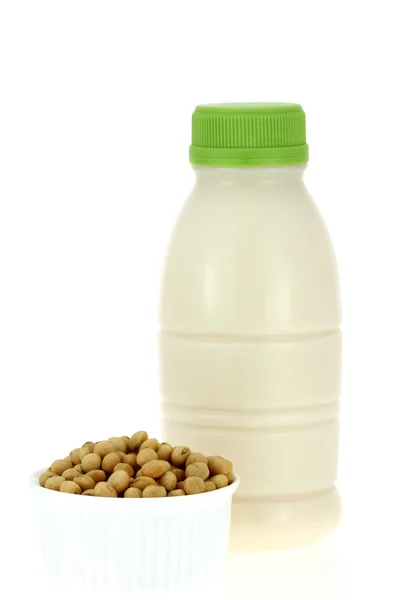 Una ciotola di soia accanto a una bottiglia di latte di soia fresco — Foto Stock