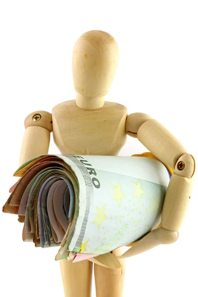 A wooden doll holding a roll of money — Stock Photo, Image