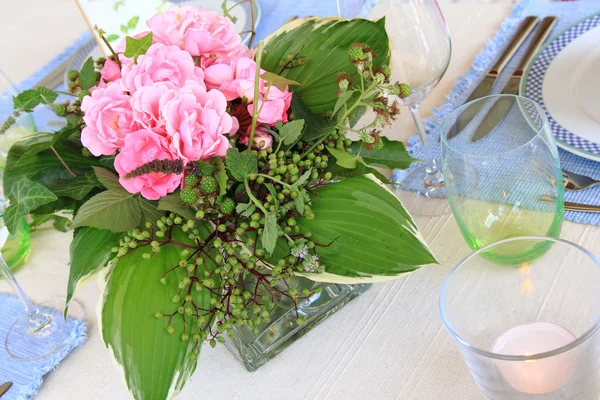 Uma mesa de jantar com um arranjo de flores — Fotografia de Stock