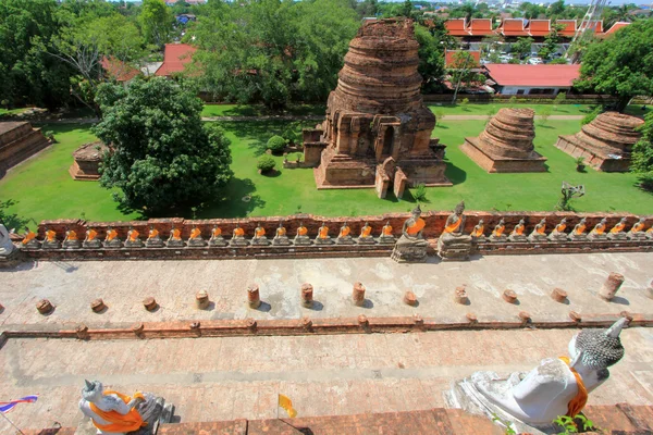 Old Chedi and Buddha Images along ruined cloister, at Wat Yai Chai Mongkol, Ayutthaya — Stock Photo, Image