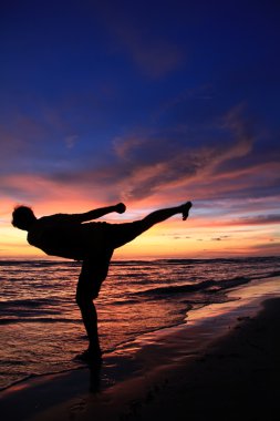 bir adam sahilde onun karate egzersiz silüeti