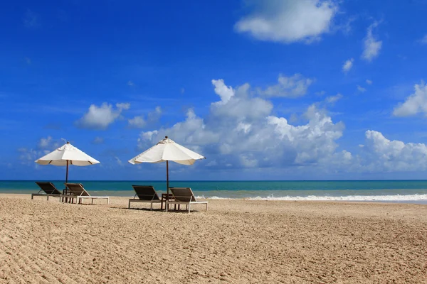 Opalovací lůžka s bílým deštníkem na tropické pláži — Stock fotografie