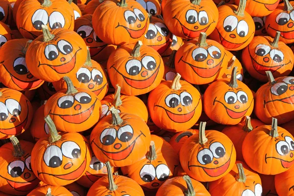 Smiley tváře maloval na čerstvé dýně na podzim — Stock fotografie