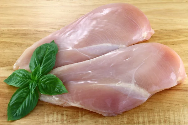 Pechuga de pollo en una tabla de cortar —  Fotos de Stock