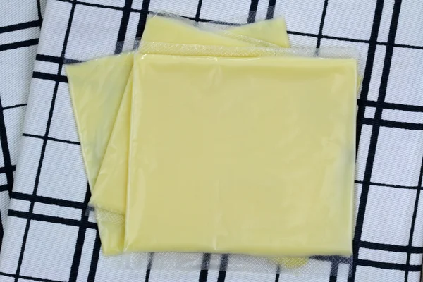 Обработанный сыр чеддер в индивидуальных завернутых слайдах — стоковое фото