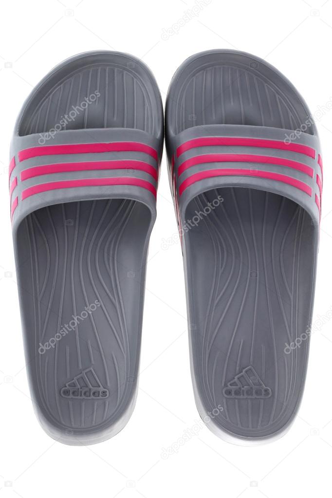 A pair of Adidas Duramo Slide sandals in Graphite with pink stripes isolated on white.