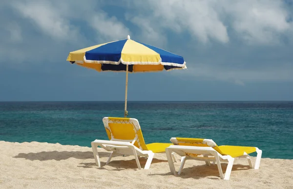 Zwei Liegestühle und Sonnenschirm — Stockfoto