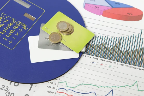 Coins and credit cards on a document with some graphics — Stock Photo, Image