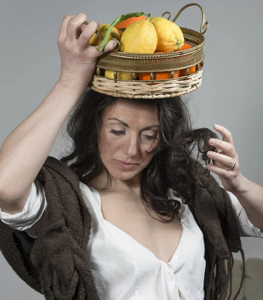 Vrouw met een mandje met fruit op haar hoofd — Stockfoto