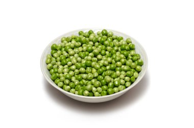 Tabakta taze kabuklu yeşil bezelyeler. Beyaz arka planda bir sürü bezelye var. İzole edilmiş resim