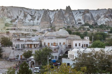 Kapadokya 'da evleri olan bir turist kasabası. Başla. Kayalıklardaki evlerin arka planında modern stil evler.
